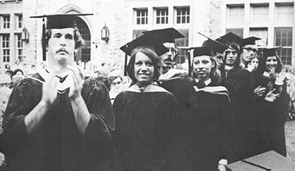 An old black and white photo of male and female students at commencement