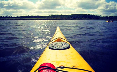 View from a yellow kayak in the water at a bright and cloudy day in the Chesapeake Bay